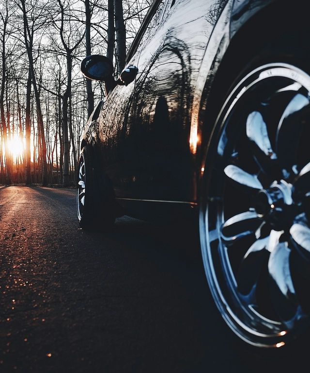 Deep-gloss black car panel with a mirror-like ceramic-coated reflection