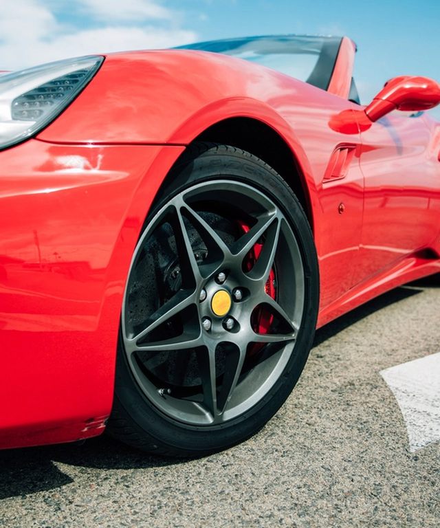 Glossy red sports car protected with clear paint protection film